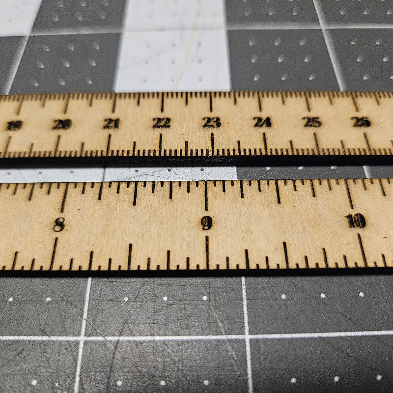 Wooden ruler on a gray cutting mat with grid lines