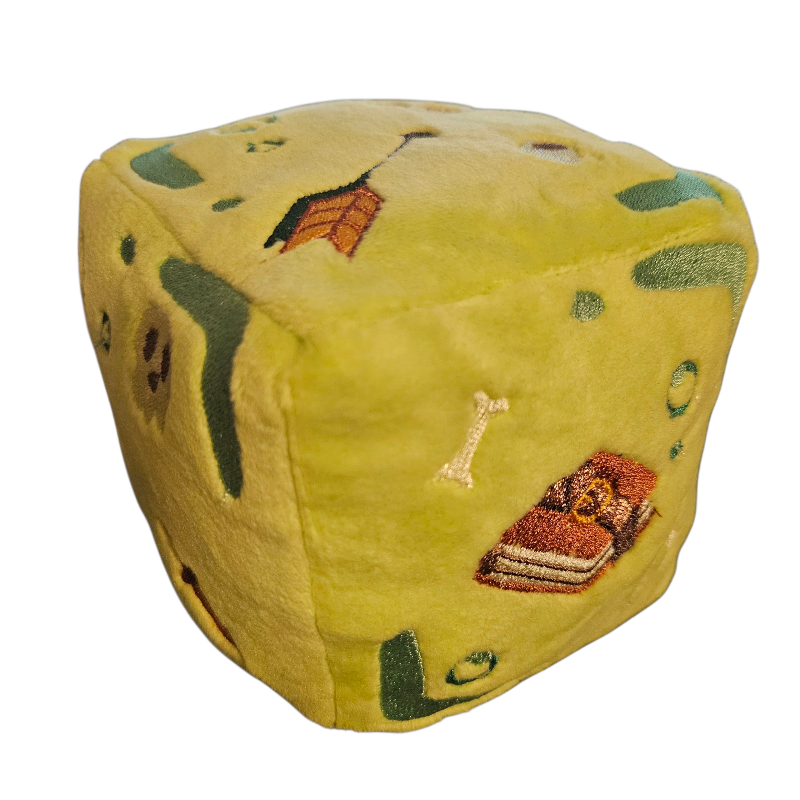 Yellow dice-shaped plush toy with embroidered designs on a white background