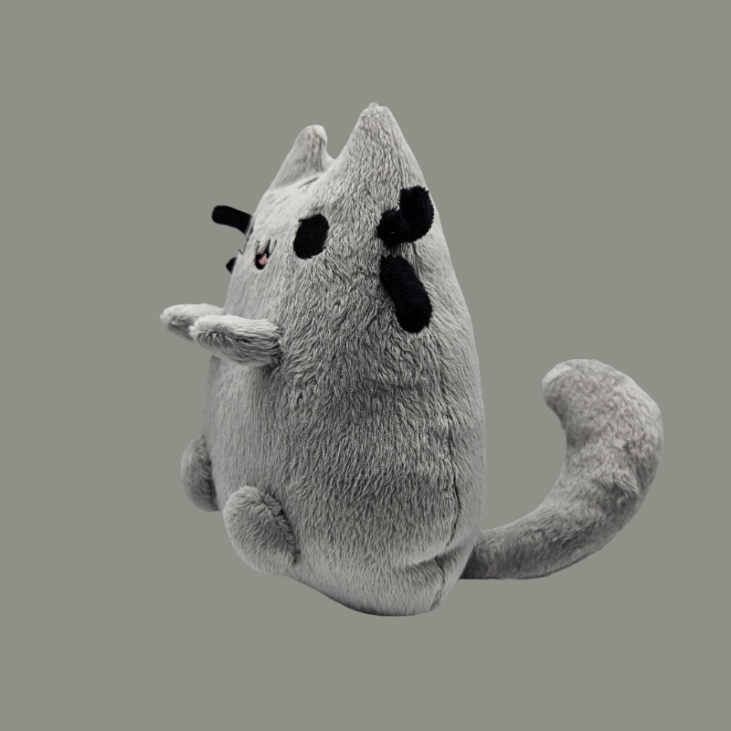 Plush toy resembling a ghost with black eyes and a small smile on a gray background