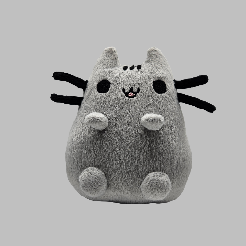 Plush toy resembling a cat with black accents on a gray background