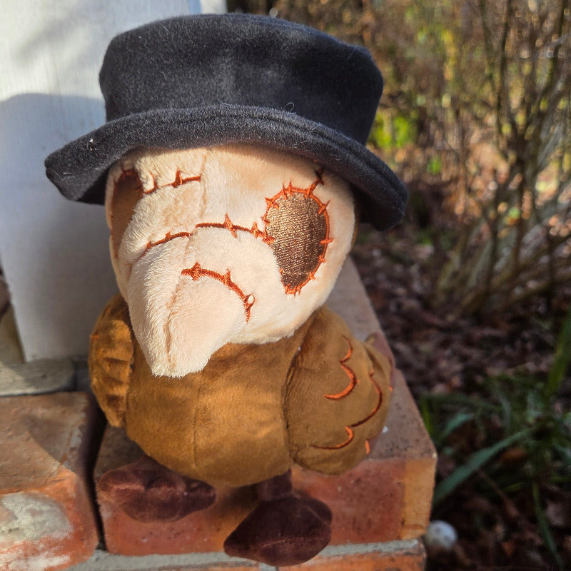 Plush toy resembling a character with a top hat on a brick surface