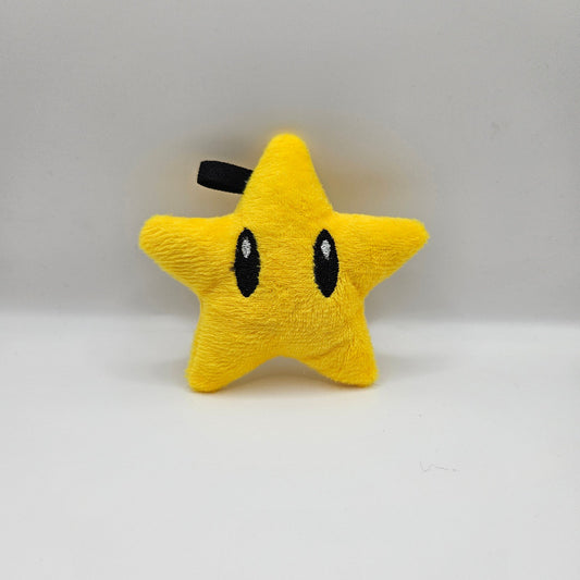 Yellow star-shaped plush toy with black details on a white background