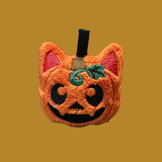 Embroidered patch with a cat face design on a plaid fabric background