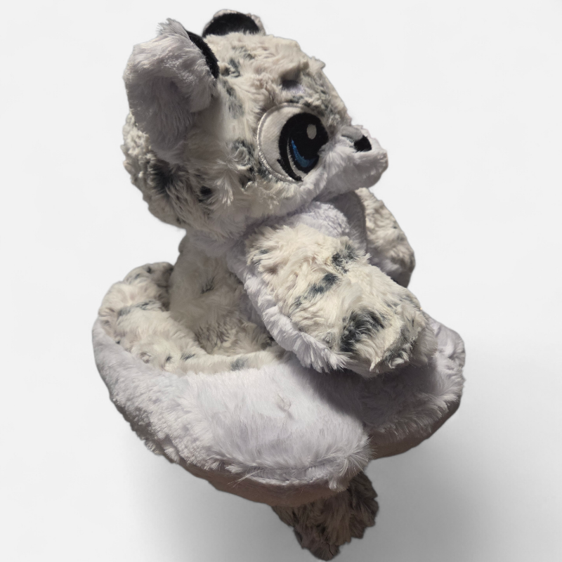 Plush toy resembling a creature with large eyes and a soft texture on a white background