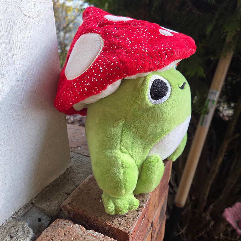 Green plush toy with a red object on a wooden surface