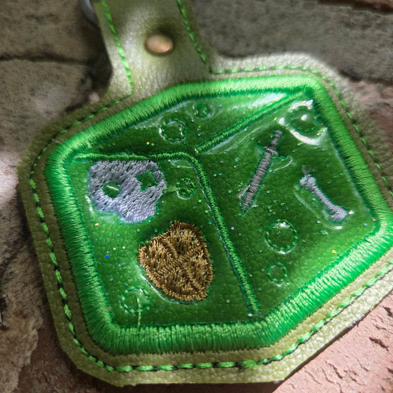 Green embroidered patch with symbols on a textured surface