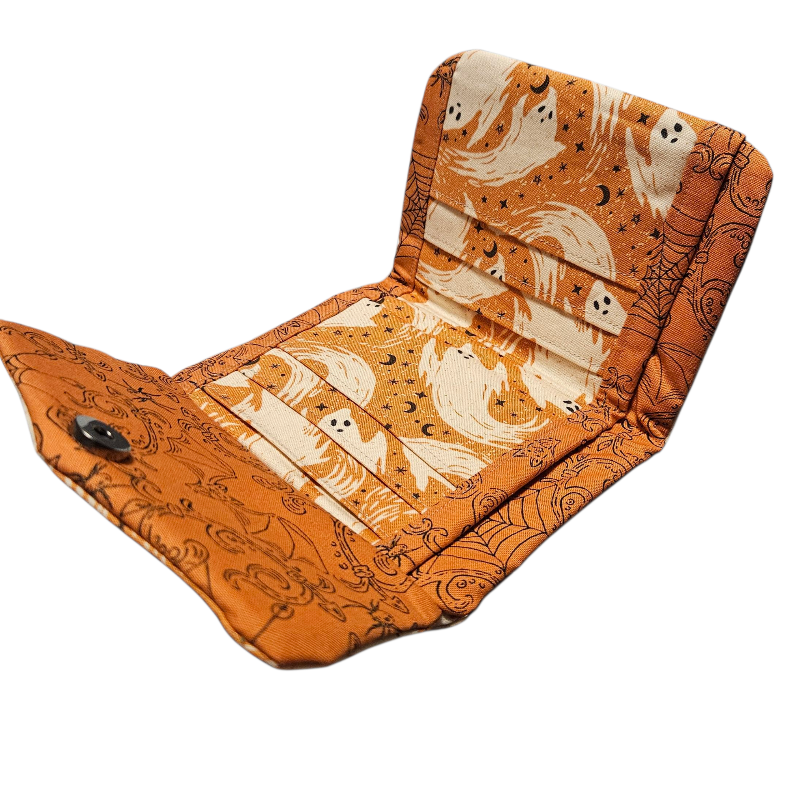Foldable wallet with Halloween-themed pattern on an orange background