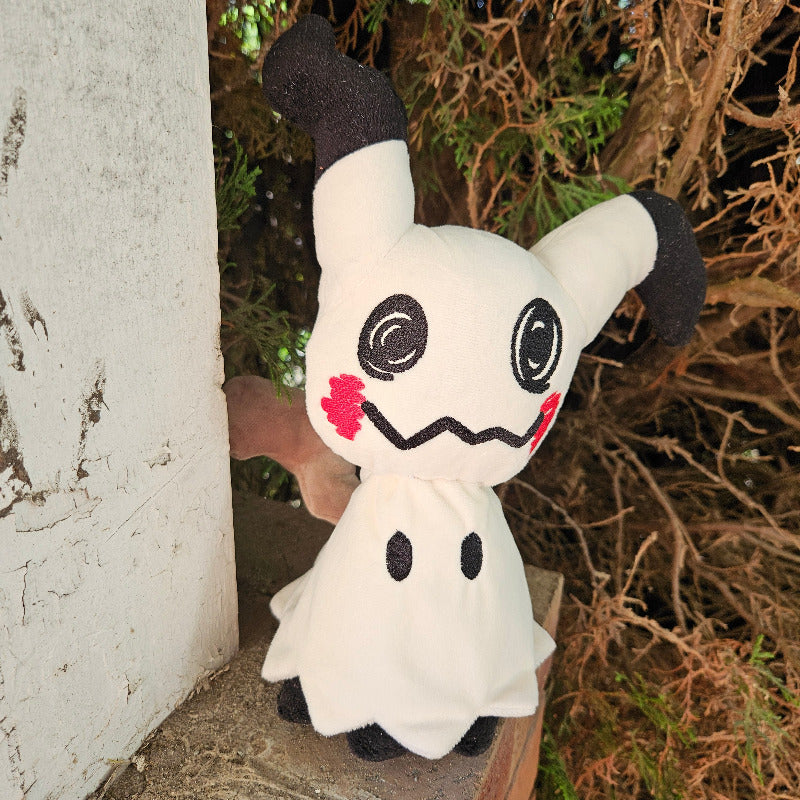 Plush toy resembling a ghost with a red bow tie peeking from behind a wall.
