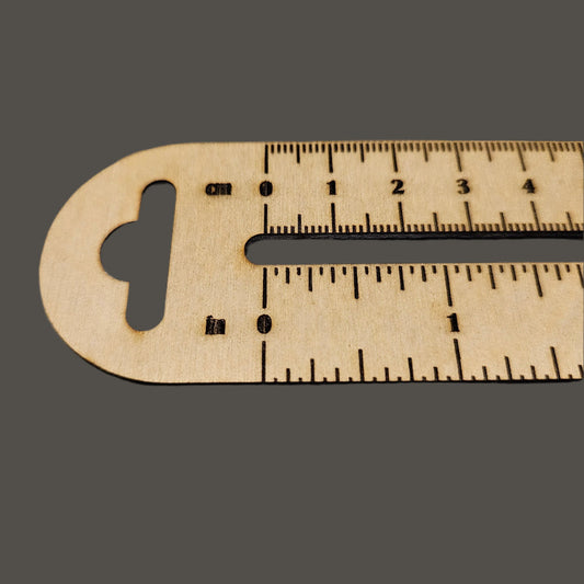 Wooden ruler with measurements on a gray cutting mat